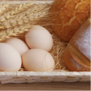 ein mit Eiern gefüllter Korb neben einem Brotlaib.